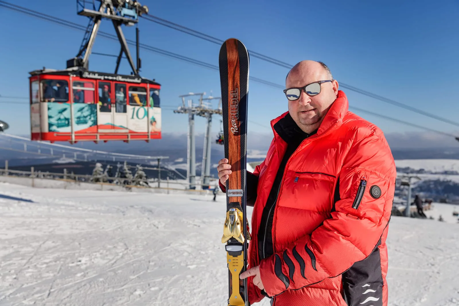 Peter Riedel mit einem Alpinski vor der Schwebebahn am Fichtelberg