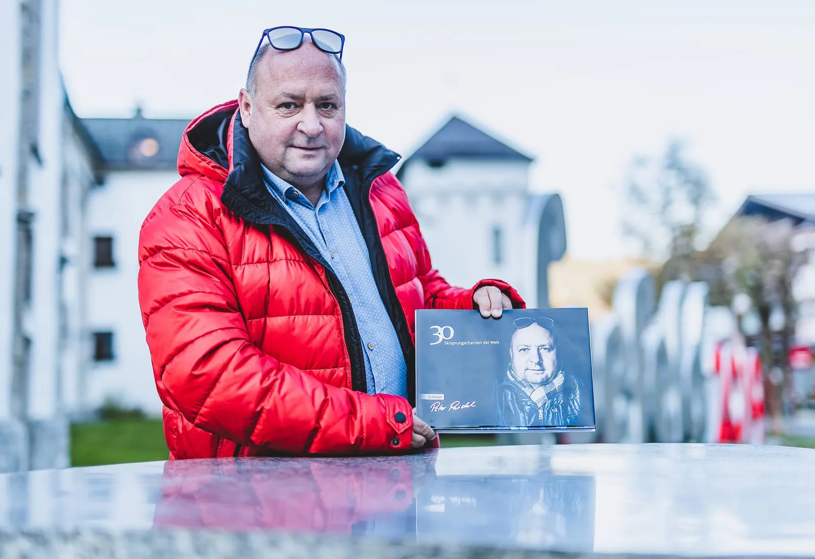 Peter Riedel mit dem Bildband „30 Skisprungschanzen der Welt“ in der Hand