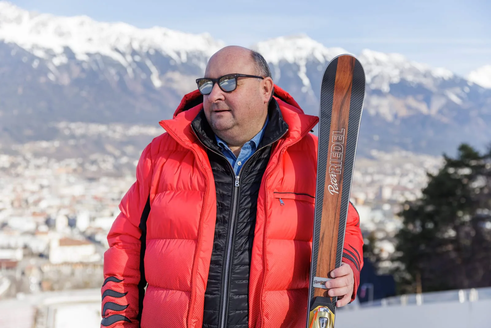 Peter Riedel mit einem handgefertigten Alpinski, im Rücken Innsbruck und die Nordkette