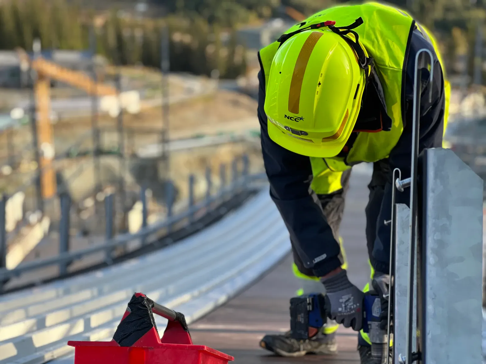 Monteur bei Wartungsarbeiten an der Anlaufspur einer Skisprungschanze