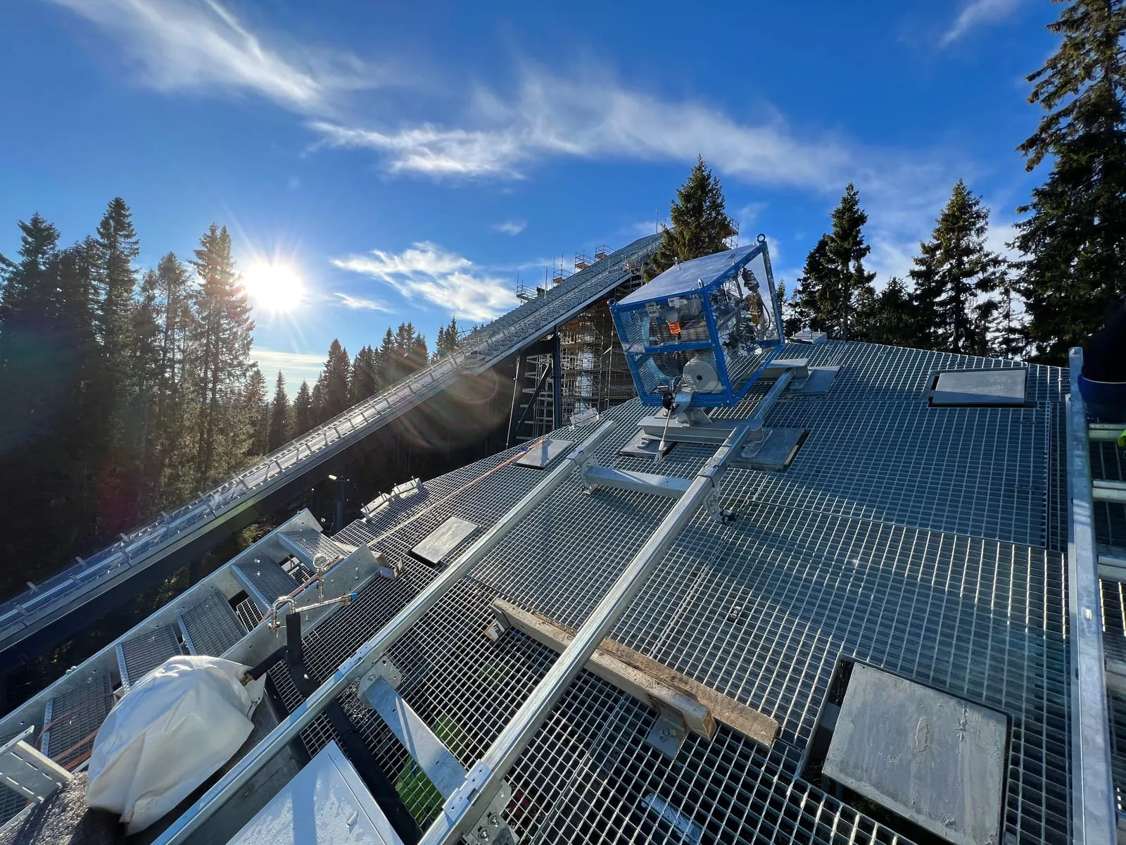 Maschinenwagen mit Seiltrommel und Umlenkrollen auf der Schiene einer Schanze im Gegenlicht